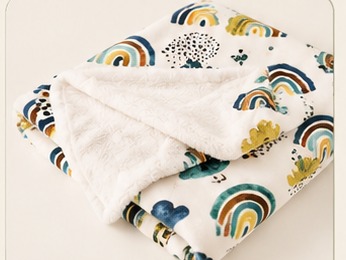 Manta MimiBaby dobrada, mostrando o lado estampado e o lado plush branco